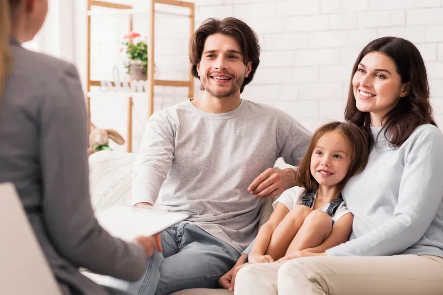 Parents With Little Daughter Sitting At Psycholigist’s Office